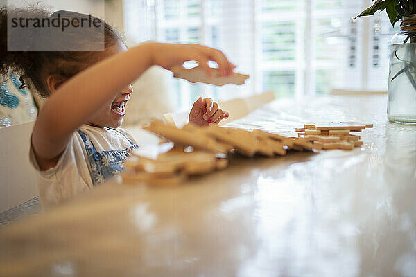 Mädchen spielt mit Holzpuzzleteilen