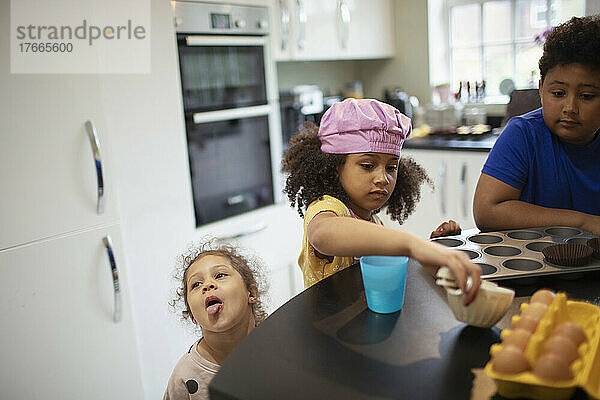 Bruder und Schwestern backen Cupcakes in der Küche