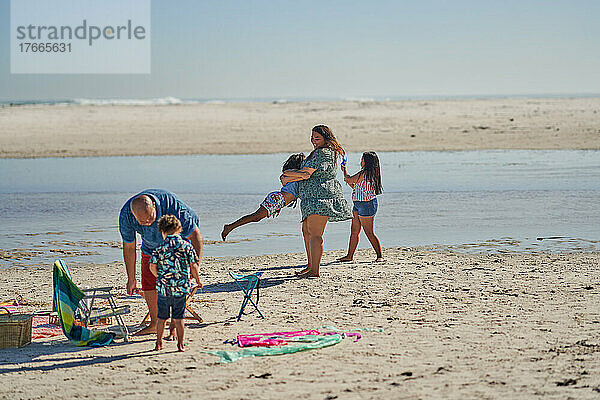 Familie spielt am sonnigen Meeresstrand