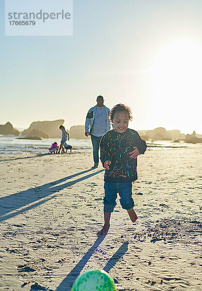 Sorgloser Junge mit Down-Syndrom spielt am sonnigen Strand