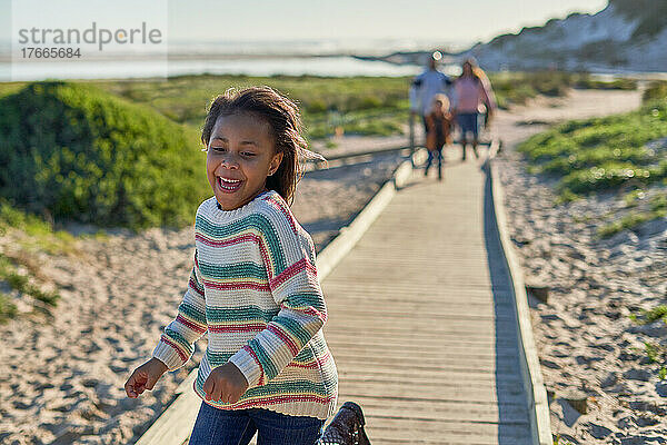 Glückliches Mädchen  das auf der Strandpromenade läuft