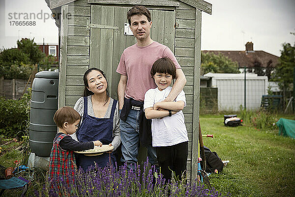 Porträt einer glücklichen Familie im Gartenhaus