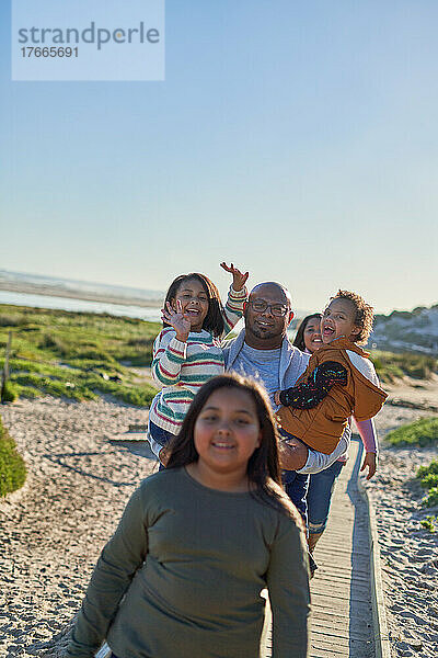 Glückliche Familie auf der sonnigen Strandpromenade