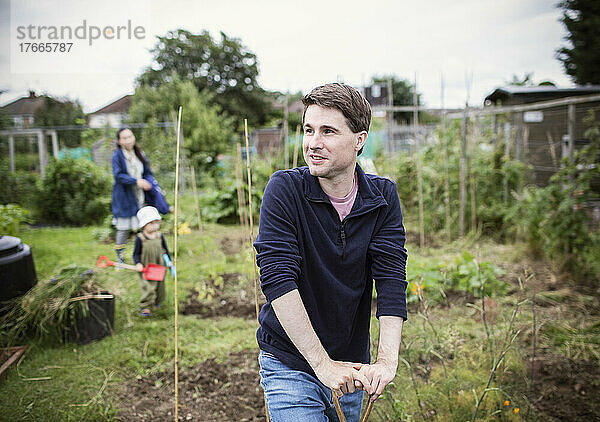 Porträt lächelnder Mann  der im Garten wegschaut