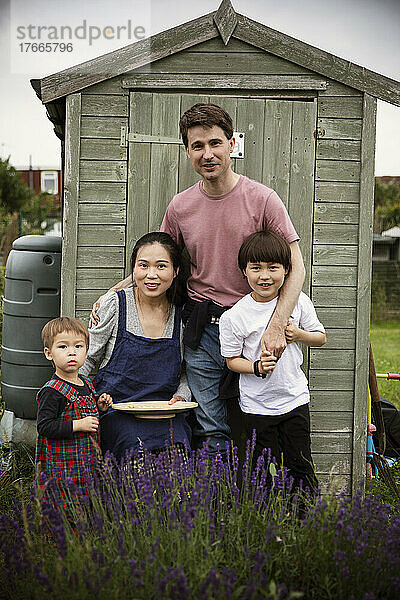 Porträt einer glücklichen Familie im Gartenhaus