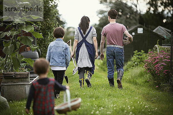 Familie spaziert im Gartengras im Hinterhof