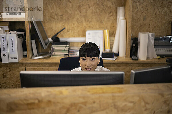 Porträt einer lächelnden Geschäftsfrau  die am Computer arbeitet