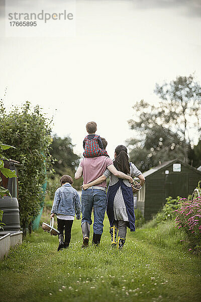 Liebevolle Familie geht im Garten spazieren
