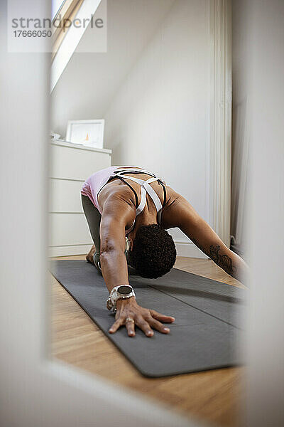 Frau übt Yoga-Kindpose auf einer Trainingsmatte