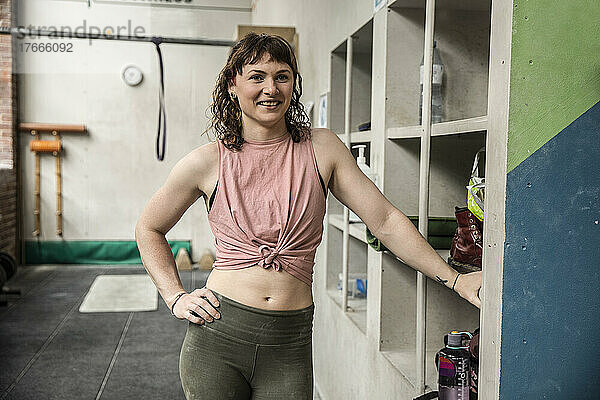 Porträt einer selbstbewussten jungen Frau  die im Fitnessstudio trainiert