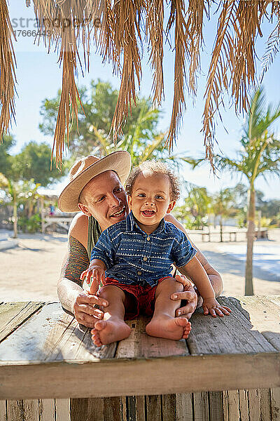 Porträt glücklicher Vater und kleiner Sohn in der Strandhütte