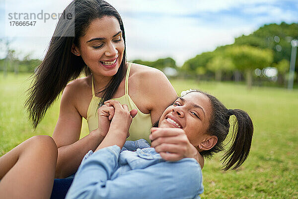 Porträt einer glücklichen Mutter und einer behinderten Tochter  die Parkgras legen