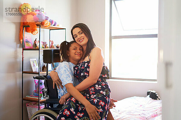 Porträt einer glücklichen  liebevollen Mutter  die ihre behinderte Tochter zu Hause umarmt