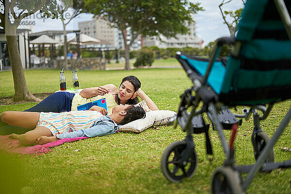 Mutter und behinderte Tochter liegen und reden im Park