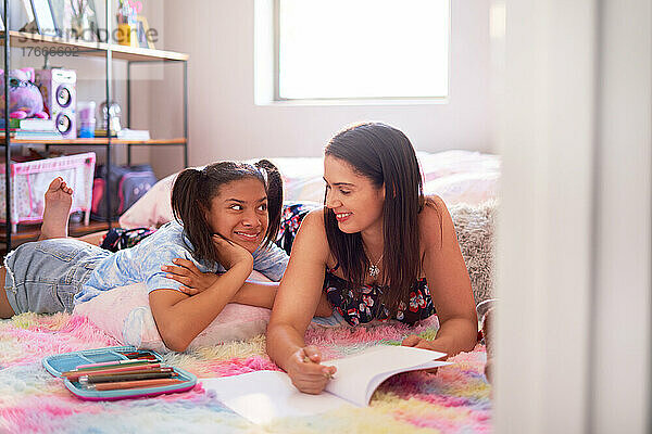Glückliche Mutter und Tochter zeichnen auf Schlafzimmerteppich