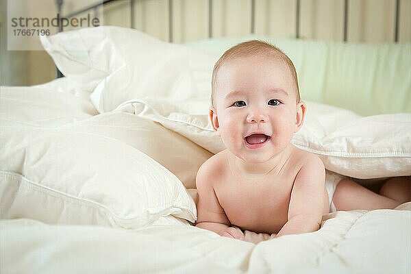 Junges gemischtrassiges chinesisches und kaukasisches Baby hat Spaß auf seiner Decke