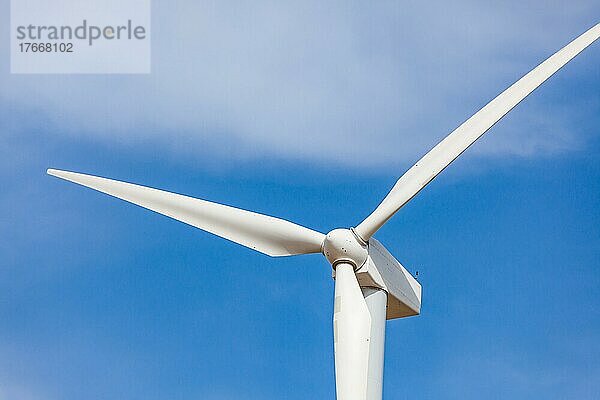 Einzelne Windkraftanlage vor dramatisch blauem Himmel