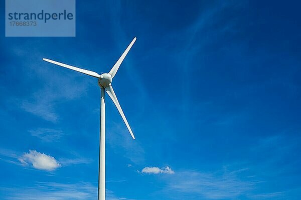 Green renewable alternative energy concept  wind generator turbines generating electricity in blue sky