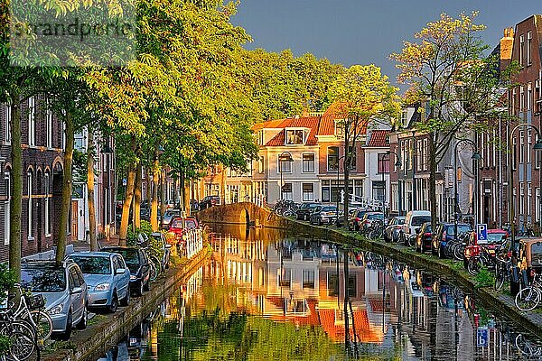 Delt canal with old houses and cars parked along on sunset  Delft  Netherlands