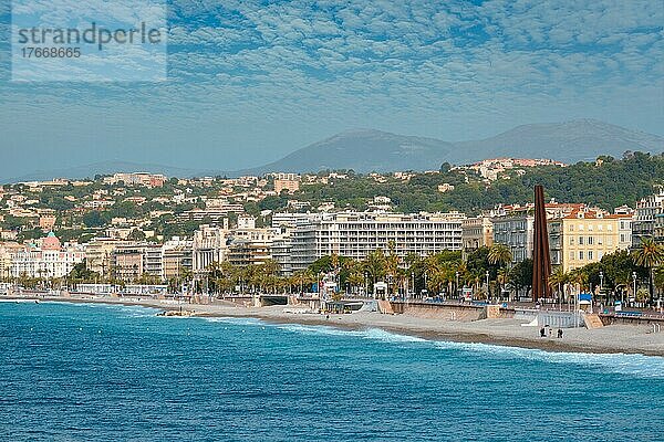 Picturesque scenic view of Mediterranean sea coast in Nice  France  Mediterranean Sea waves surging on the coast  people are relaxing on the beach  Nice  France