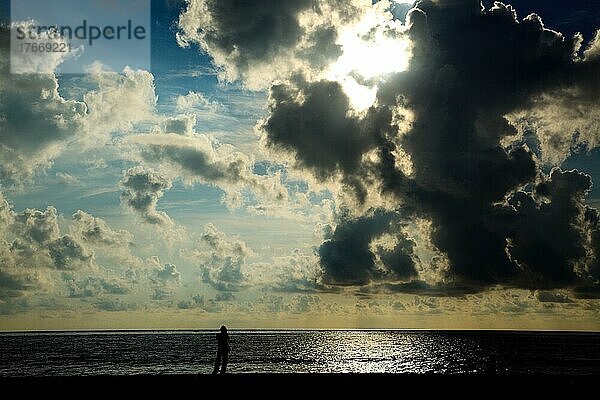 Man silhouette standing on beach on sunrise