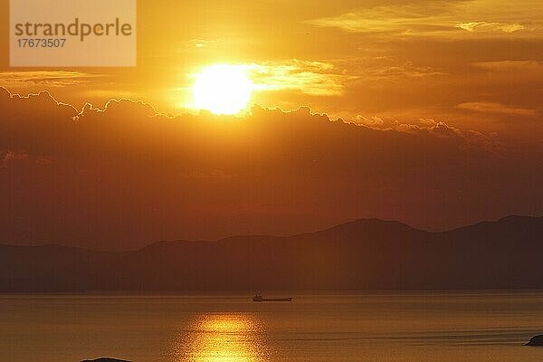 Sonnentreflektionen  Abendhimmel orange  Sonnenuntergang  Schiff  Festland Berge im Hintergrund  Landzunge  Wolken  Abendhimmel rot  Insel Andros  Kykladen  Griechenland  Europa