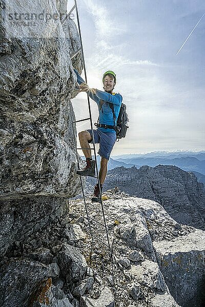 Wanderer in einem gesicherten Steig  besteigt eine Leiter  Sonnenstern  Aufstieg zum Mitterhorn  steile felsige Berglandschaft  Nuaracher Höhenweg  Loferer Steinberge  Tirol  Österreich  Europa