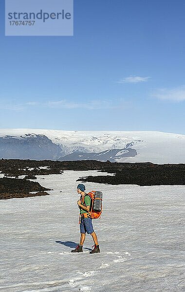 Wanderer auf Schneefeld  Karge hügelige Vulkanlandschaft aus Schnee und Lavafeldern  hinten Gletscher Myrdalsjökull  Wanderweg Fimmvörðuháls  Þórsmörk Nature Reserve  Suðurland  Island  Europa