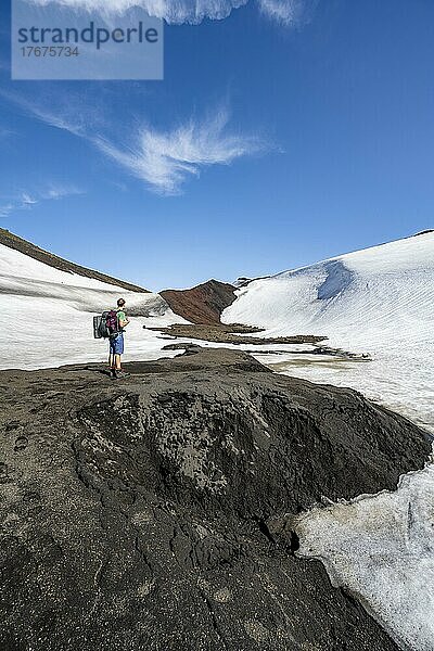 Wanderer auf dem Wanderweg Fimmvörðuháls  karge Vulkanlandschaft  Lavasand und Schneefelder  Þórsmörk Nature Reserve  Suðurland  Island  Europa