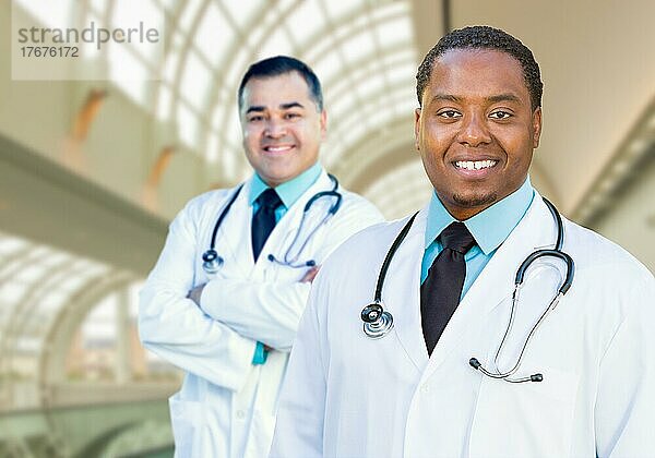 African american and caucasian male doctors inside hospital office