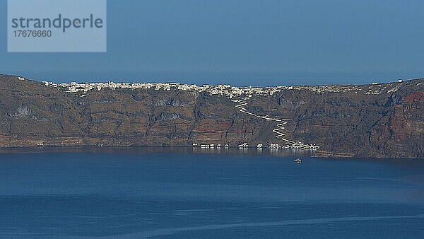 Morgenlicht  ruhiges Meer  Steilküste  rote Lavafelsen  Häuser  weißer gepflasterter Weg hinauf  Thirasiá  Insel Santorini  Kykladen  Griechenland  Europa