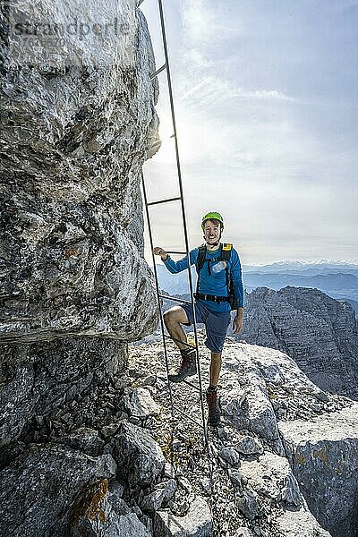 Wanderer in einem gesicherten Steig  besteigt eine Leiter  Aufstieg zum Mitterhorn  steile felsige Berglandschaft  Nuaracher Höhenweg  Loferer Steinberge  Tirol  Österreich  Europa