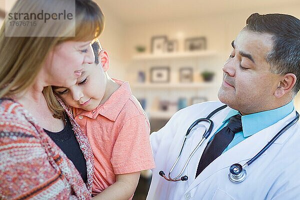 Young sick boy and mother visiting with hispanic doctor in office