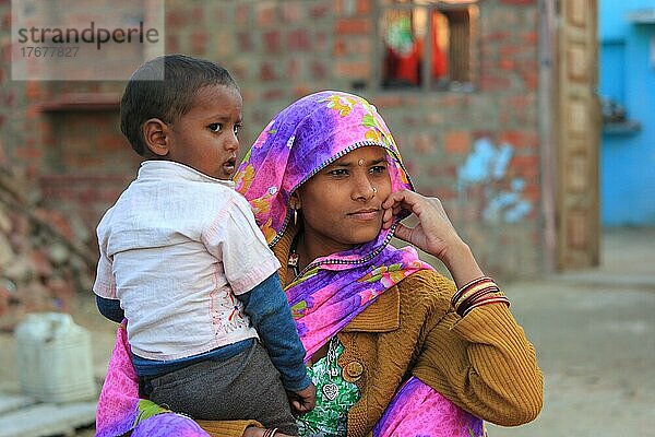 Nordindien  Rajasthan  junge Frau mit Tuch auf dem Kopf und ihrem kleinen Jungen auf dem Arm  Indien  Asien