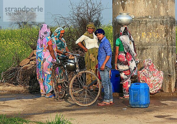 Nordindien  Rajasthan  Frauen und ein Mann mit Fahrrad holen Wasser am Brunnen  in einem Dorf nahe Bharatpur  Indien  Asien