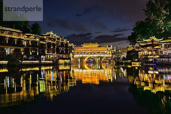 Chinesische Touristenattraktion  die alte Stadt Feng Huang (alte Stadt des Phönix) am Fluss Tuo Jiang bei Nacht beleuchtet. Provinz Hunan  China  Asien