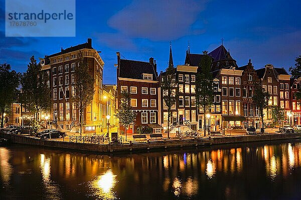 Nachtansicht der Stadt Amterdam mit Grachten und mittelalterlichen Häusern in der Abenddämmerung beleuchtet. Amsterdam  Niederlande  Europa