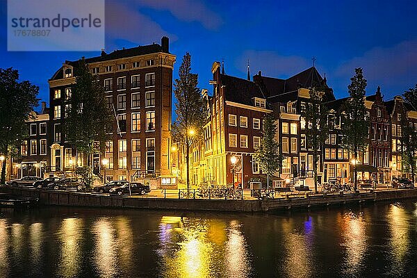 Nachtansicht der Stadt Amterdam mit Grachten und mittelalterlichen Häusern in der Abenddämmerung beleuchtet. Amsterdam  Niederlande  Europa