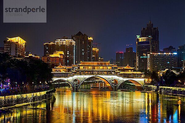 Berühmtes Wahrzeichen von Chengdu  Anshun-Brücke über den Jin-Fluss  beleuchtet bei Nacht mit modernen Wolkenkratzern im Hintergrund  Chengdu  Sichuan  China  Asien