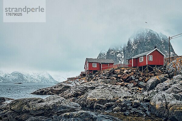 Berühmte Touristenattraktion Hamnoy  Fischerdorf auf den Lofoten  Norwegen  mit roten Rorbu-Häusern. Mit fallendem Schnee im Winter  Europa