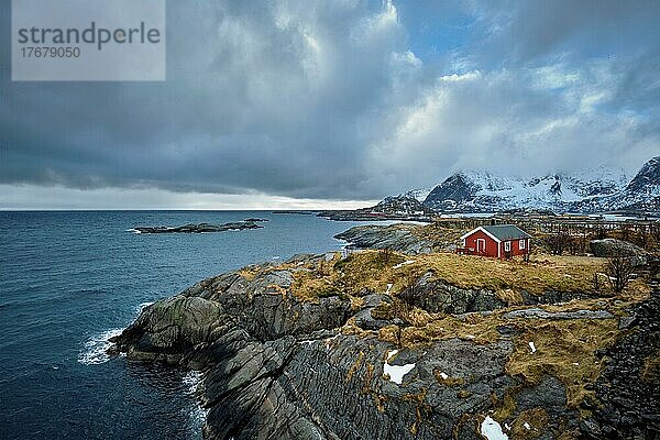 Klippe mit traditionellem roten Rorbu-Haus auf der Insel Litl-Toppoya auf den Lofoten  Norwegen im Winter