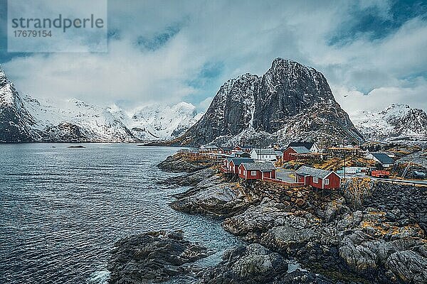 Berühmte Touristenattraktion Hamnoy  Fischerdorf auf den Lofoten  Norwegen  mit roten Rorbu-Häusern. Mit fallendem Schnee im Winter  Europa