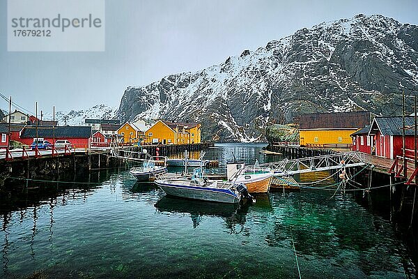 Pier mit Booten im Nusfjord Authentisches Fischerdorf im Winter mit roten Rorbu-Häusern. Lofoten Inseln  Norwegen  Europa