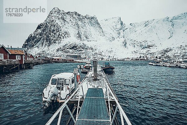 Pier mit Booten im Fischerdorf Reine im Winter. Lofoten Inseln  Norwegen  Europa