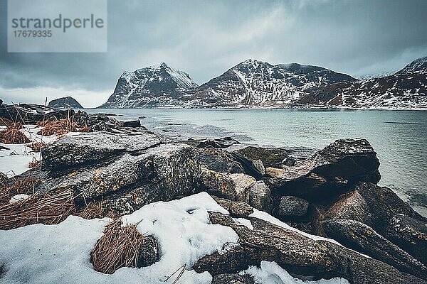 Felsküste des Fjords der norwegischen See im Winter mit Schnee. Haukland Strand  Lofoten Inseln  Norwegen  Europa
