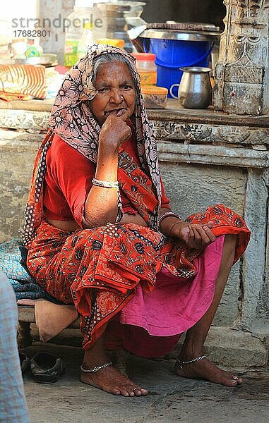 Ältere Frau in bunter Kleidung sitzt im Innenhof ihres Hauses  Rajasthan  Nordindien  Indien  Asien