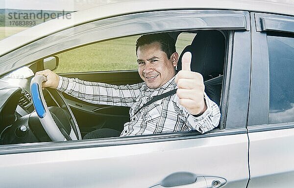 Glücklicher Mann in seinem Auto  der die Daumen nach oben streckt  Porträt eines Mannes  der beim Fahren die Daumen nach oben streckt  Mann in seinem Auto