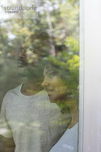 Junges Paar schaut durch ein Fenster