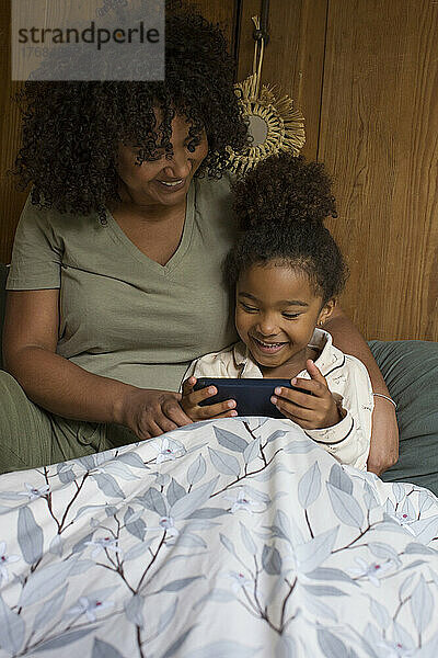 Tochter und Mutter nutzen Smartphone
