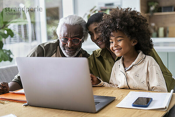 Großeltern mit Enkelin  die Laptop benutzen